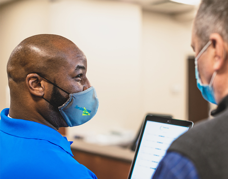 Man looking at iPad with customer